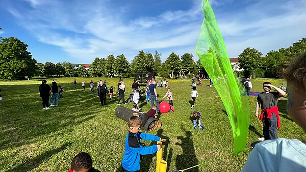 Spielende Menschen auf einer großen Wiese