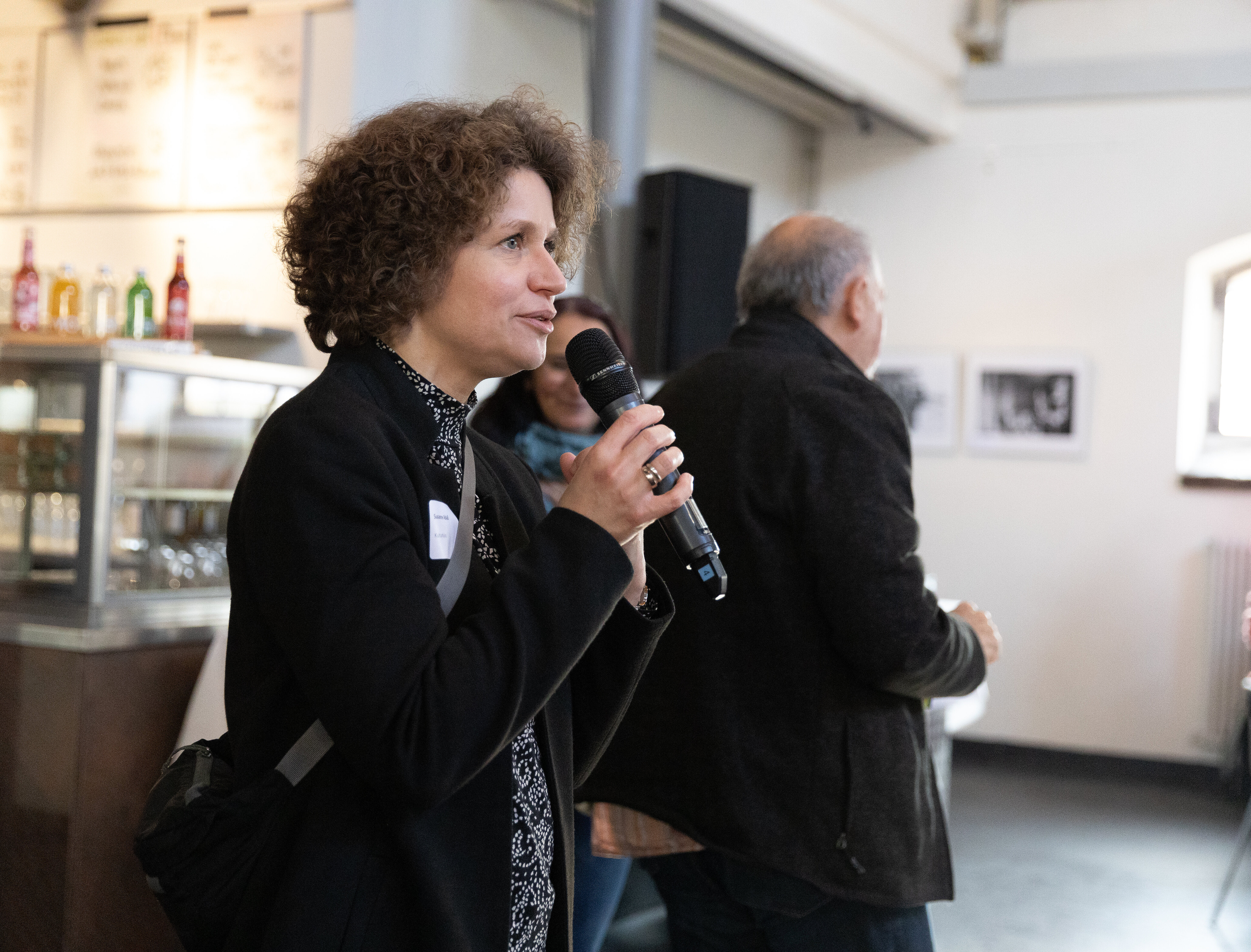 Leitern des Kulturbüros erklärt mit Mikrofon in der Hand das Walking World Café