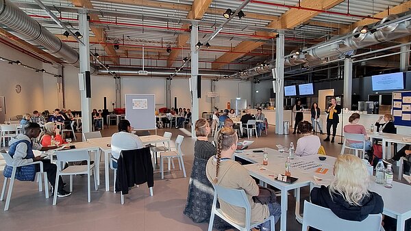 Foyer des Badischen Staatstheaters mit Teilnehmenden an Gruppentischen im Zuge des Runden Tisch Antirassismus / Antidiskriminierung am 10. Oktober 2022