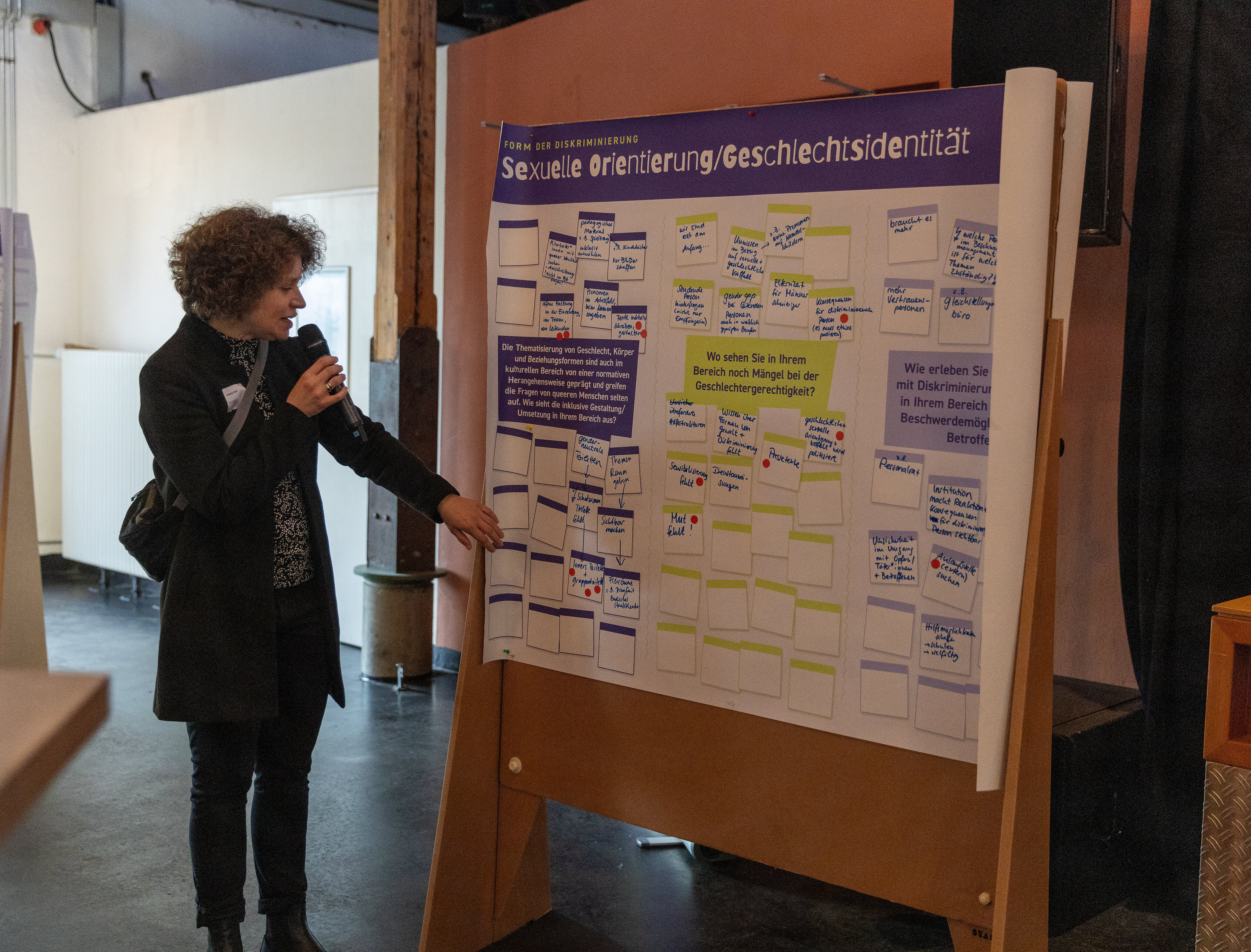 Leterin des Kulturbüros zeigt auf die Pinnwände und erklärt die Ergebnisse des Walking World Café