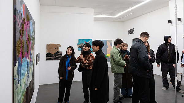 Kunst betrachtende Personen in einem weißen Ausstellungsraum